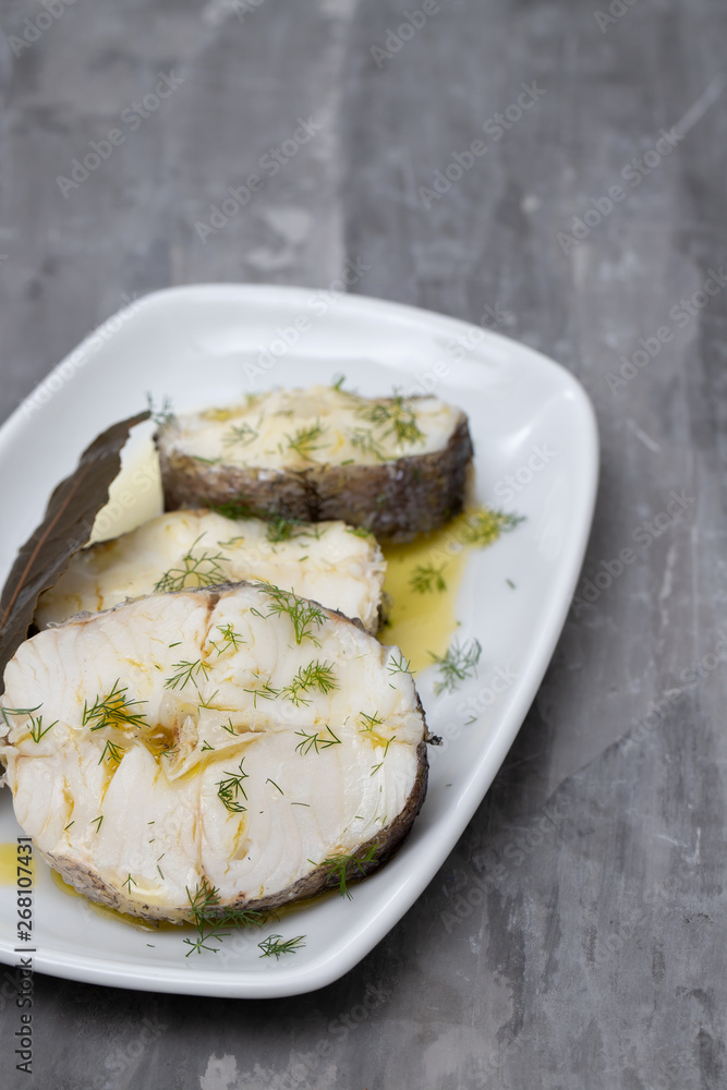 boiled fish with olive oil and bay leaf in white dish boiled fish with olive oil and bay leaf in white dish