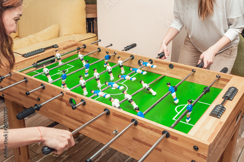 Friends girls take a break and play table football and have fun