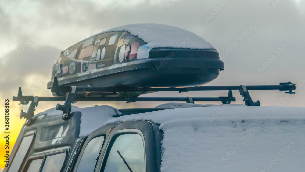 Panorama Black vehicle with a roof rack and rooftop cargo carrier viewed in winter Panorama Black vehicle with a roof rack and rooftop cargo carrier viewed in winter