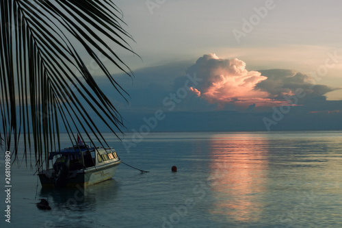 boat moored near a beach at  tropical sunset on the sea © raffaellagalvani