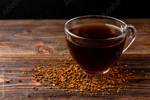 Granulated coffee on dark wooden background.