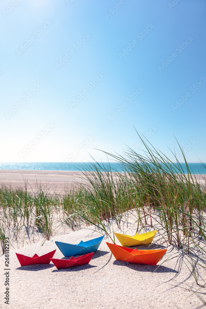 Fototapeta premium Papierschiffe in den Dünen am Meer