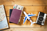 Preparación concepto de viaje, avión, dinero, pasaporte, mapa sobre mesa rústica de madera vista arriba