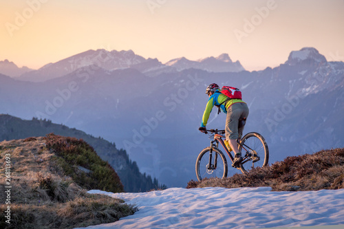 Male mountainbiker on a trail in the mountains at sunset