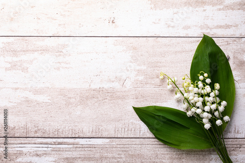 Spring holiday, lilies of the valley on a white wooden background. photo