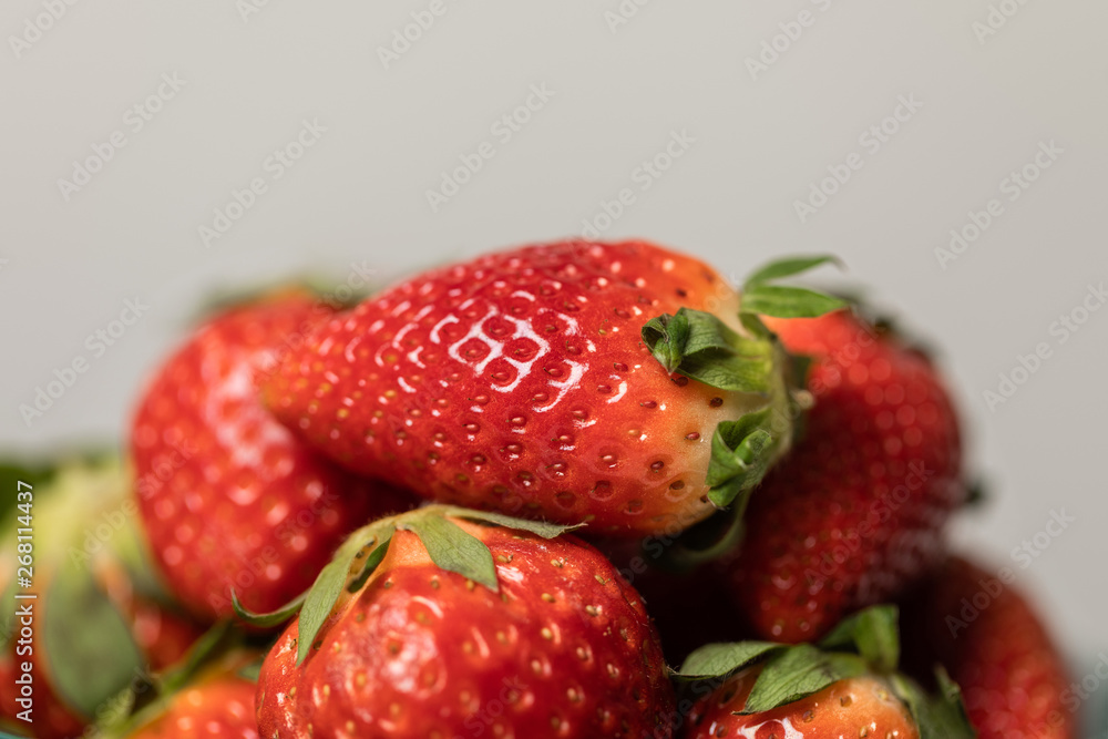 selective focus of red sweet and organic strawberries on grey selective focus of red sweet and organic strawberries on grey