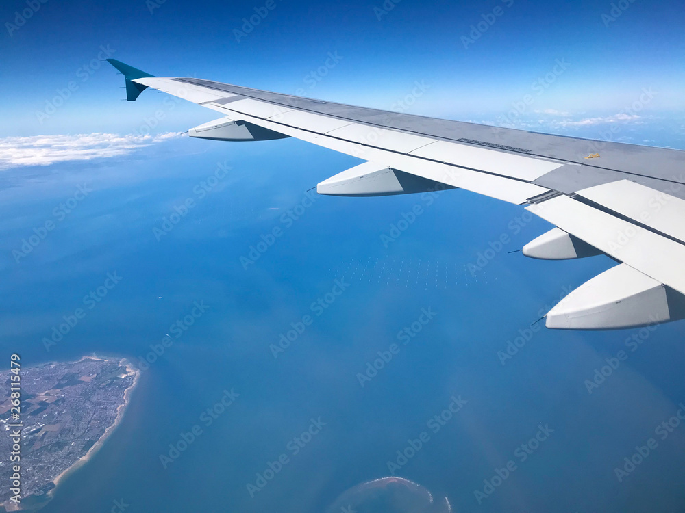 Naklejka premium vol avion survol mer ocean aile
