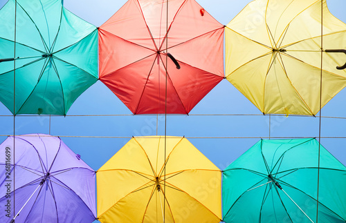 The image of colorful umbrellas on a background of blue sky