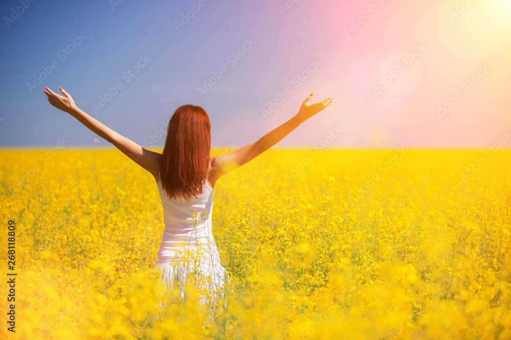 People freedom success concept. Happy woman in the field with flowers at sunny day in the countryside. Nature beauty background, blue sky and yellow flowers. Outdoor lifestyle. People freedom success concept. Happy woman in the field with flowers at sunny day in the countryside. Nature beauty background, blue sky and yellow flowers. Outdoor lifestyle.