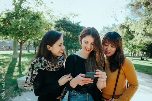 group of three friends talking and walking on the street. 