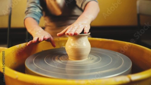 Handcraft Pottery inside. childrens Hands working on pottery wheel, shaping a clay vase. Children Making Pottery In Workshop, potter's wheels in the pottery workshop photo