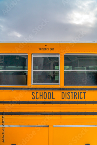 CLose up of the exterior of a yellow school bus against cloudy sky