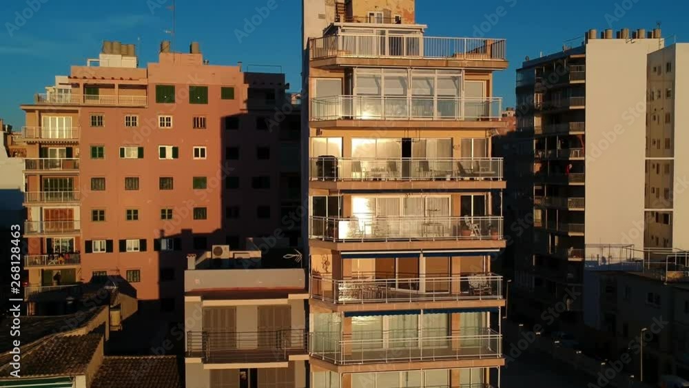 Drone flying up and over an apartment building in a city on the coast of the island of Mallorca Spain at sunset Drone flying up and over an apartment building in a city on the coast of the island of Mallorca Spain at sunset