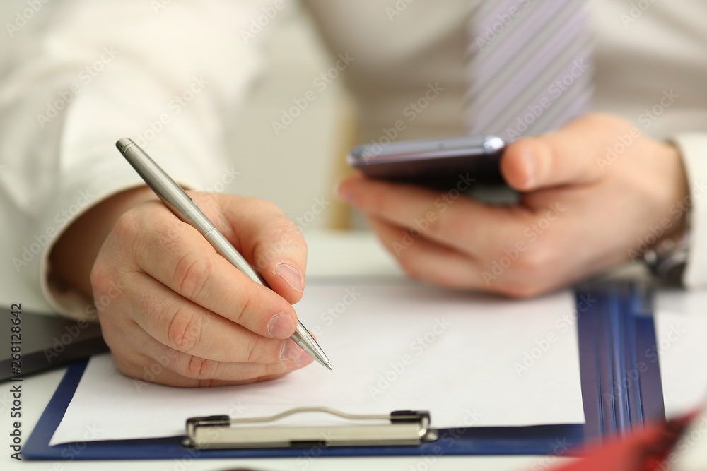 Male arm in suit and tie hold silver pen filling schedule in notepad at office workplace closeup. Legal law consult assistance gesture or finance investment advisor clerk job information gesture Male arm in suit and tie hold silver pen filling schedule in notepad at office workplace closeup. Legal law consult assistance gesture or finance investment advisor clerk job information gesture
