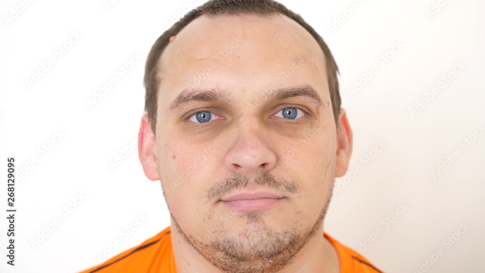 Fototapeta premium Face of young attractive bearded man with blue eyes on a white background