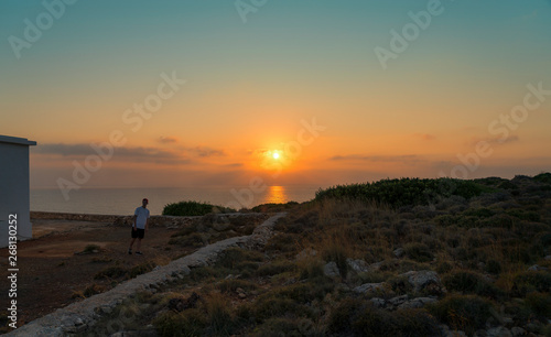 sunset over the sea and walking young man