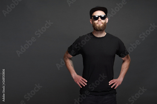 Hipster handsome male model with beard wearing black blank baseball cap with space for your logo