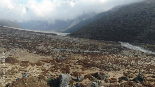 4k aerial fly through Langtang Valley in Nepal with man on rocks photo