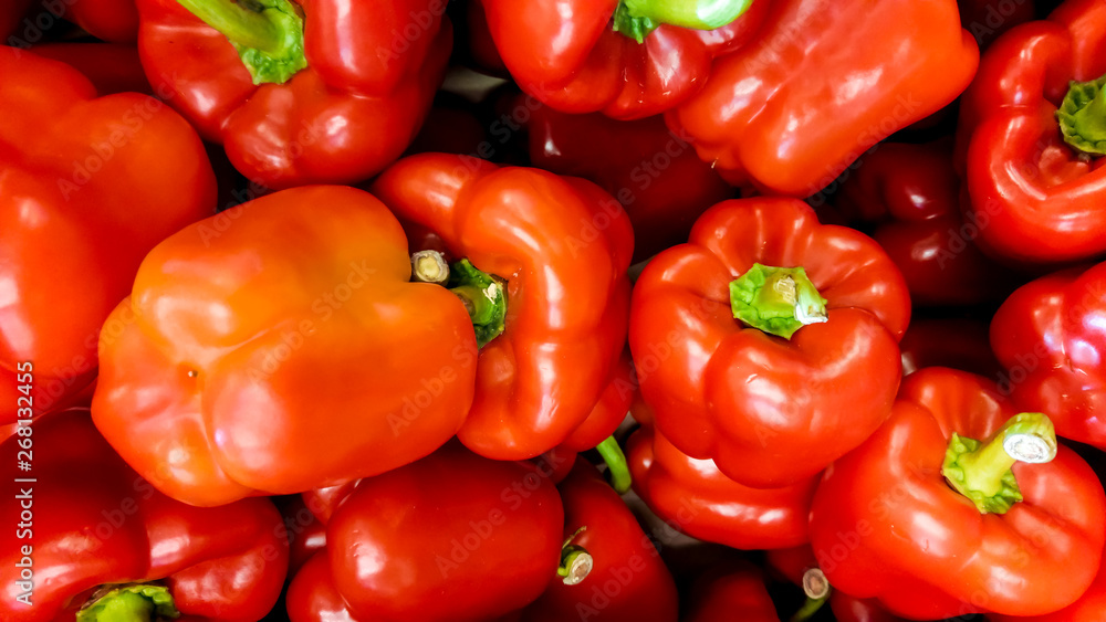 Macro image of lots of red paprica lying on store counter. Texture or pattern of fresh ripe vegetables Macro image of lots of red paprica lying on store counter. Texture or pattern of fresh ripe vegetables