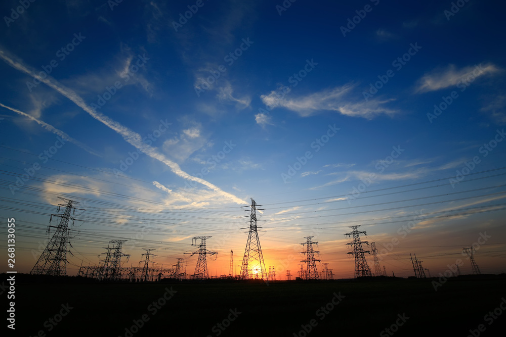 A silhouette of a high voltage tower at sunset