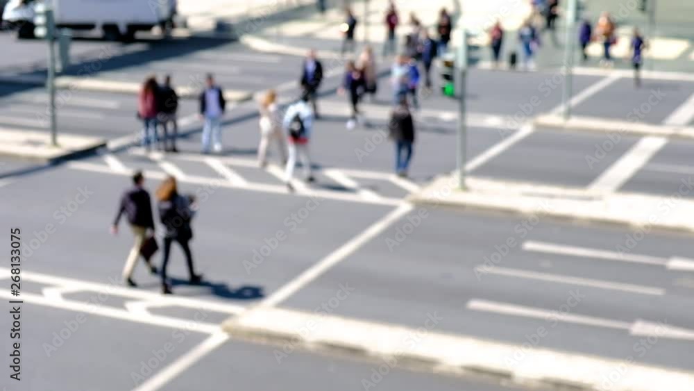 Blurred view of moving cars and people walking across the street, people cross the road, blurred background. Blurred view of moving cars and people walking across the street, people cross the road, blurred background.