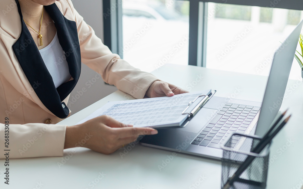 Fototapeta premium Business woman working and analysis on laptop with financial document data graph of business strategy and market growth at workplace.