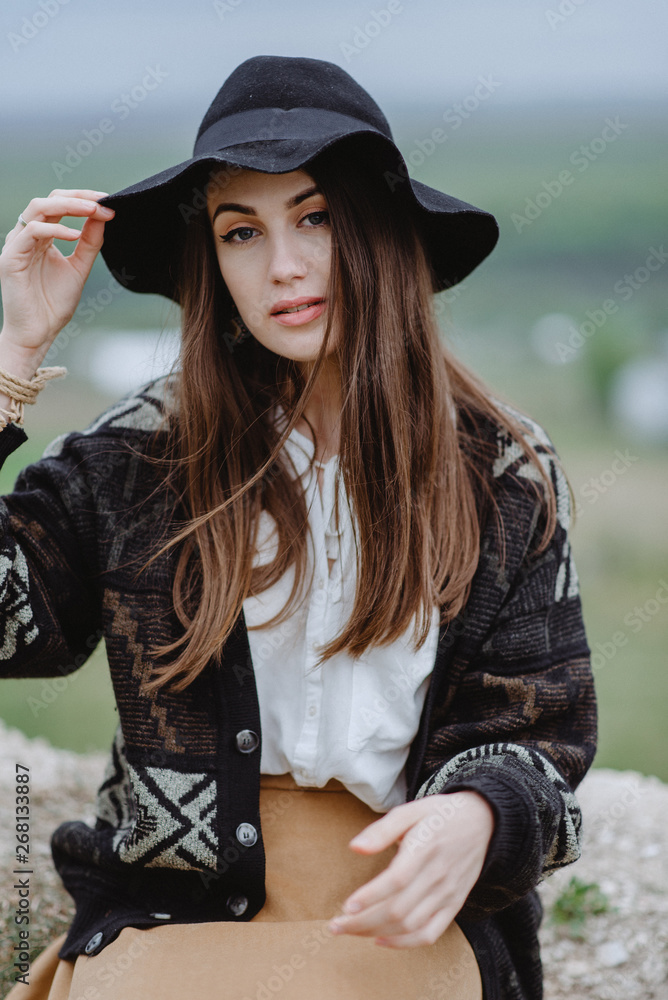 Beautiful girl with a hat on top of a mountain in anticipation. Calm portrait of Amish girl