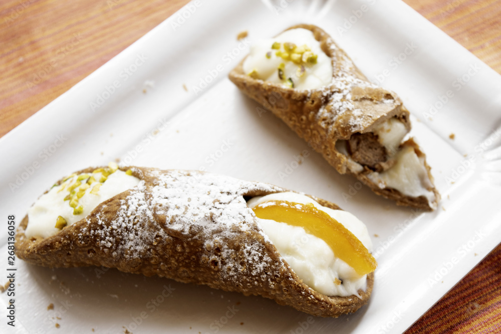  sicilian cannolo whole and one already eaten at half