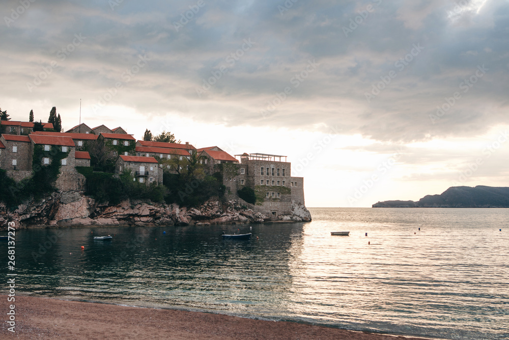 View of the sea and the island of Sveti Stefan on the background of the sunset in Montenegro. This is one of the main attractions of Montenegro.