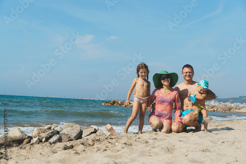 couple with kids at posing on beach