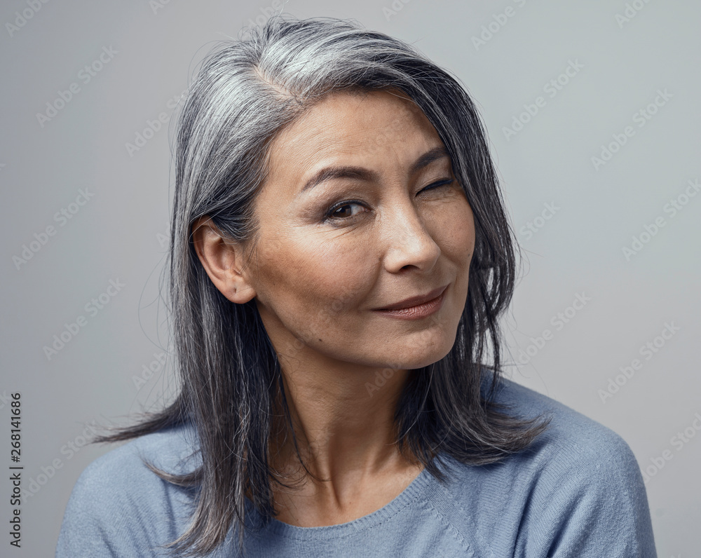 Charming Asian mature woman smiles at camera Stock Photo | Adobe Stock