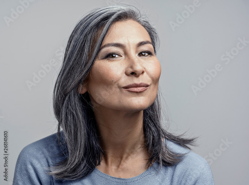 Obraz na plátně Charming Asian mature woman smiles at camera