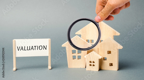 Photography A poster with the word Valuation and a miniature wooden house