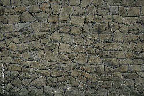 Gray green stone wall texture background. Rock texture. Green granite stone surface. Mosaic pattern of grey stones on the cement wall. Old dirty wall rocks texture. Green backdrop of decorative tiles.