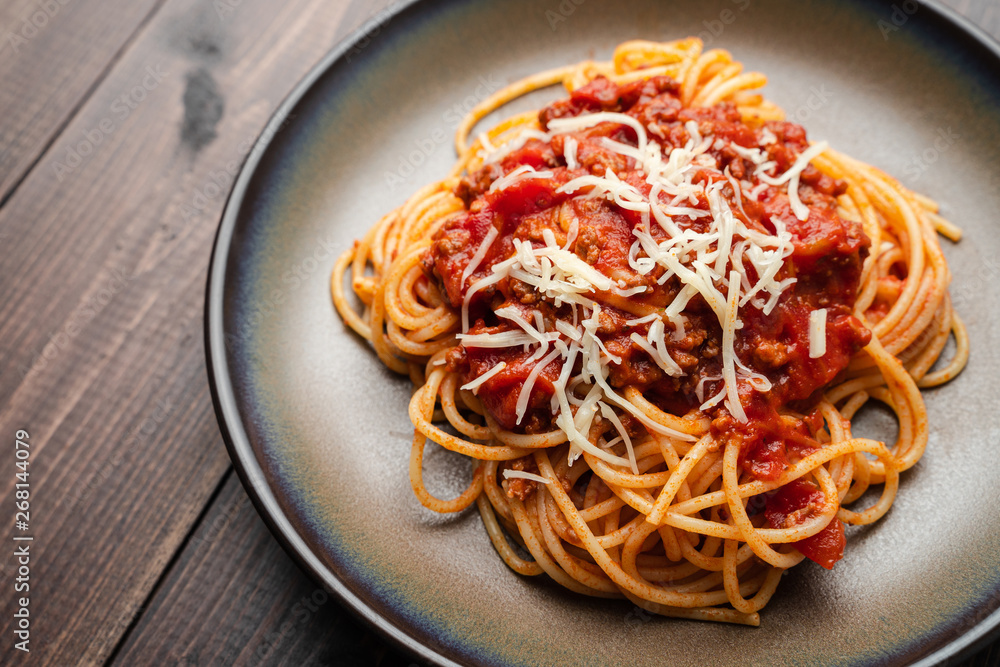 Spaghetti Bolognese sauce or tomato sauce on a dark wooden board, traditional Italian food closeup and top view Spaghetti Bolognese sauce or tomato sauce on a dark wooden board, traditional Italian food closeup and top view