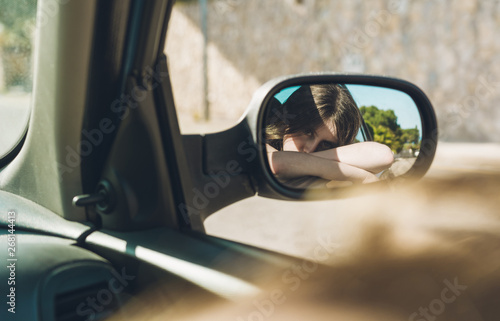 Teen girl sitting in the car on a summer afternoon © expressiovisual