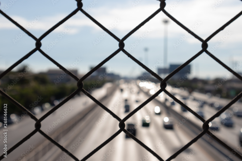 Close up steel cage with blured car on the road blue sky background. Locked up from the outside beautiful world and imprison concept. Close up steel cage with blured car on the road blue sky background. Locked up from the outside beautiful world and imprison concept.