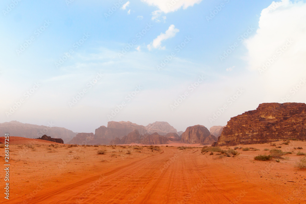 Wadi Rum desert, Jordan, Middle East, The Valley of the Moon. Red sand, mountains and haze. Designation as a UNESCO World Heritage Site.