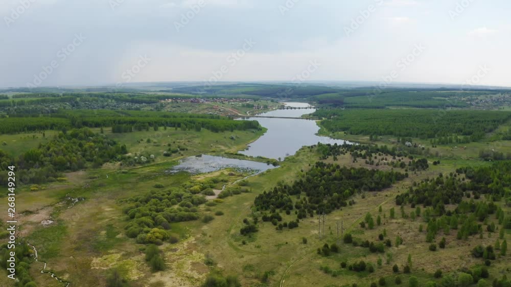 Flying over a field and pond, aerial view Flying over a field and pond, aerial view
