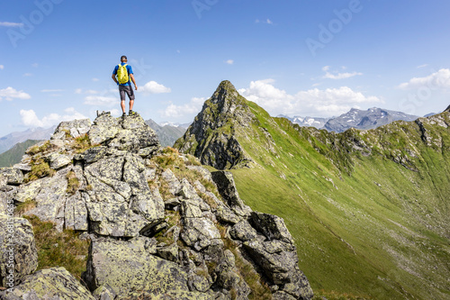 Mountaineer standing on a rock on top of a mountain