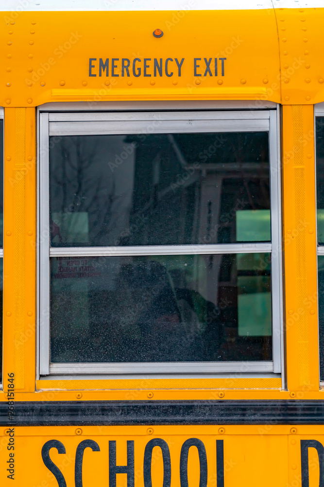 Exterior of a yellow school bus with a close up view of its glass window