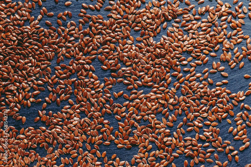 flax seeds scattered on black stone, texture