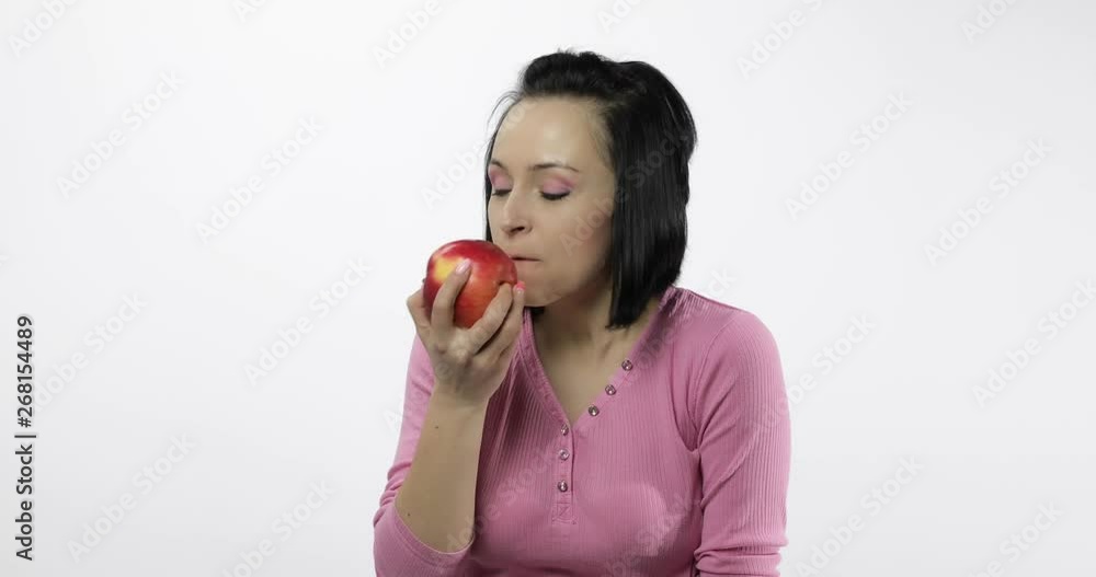 Young woman eating apple and says yum. Girl takes first bite and say wanna bite Young woman eating apple and says yum. Girl takes first bite and say wanna bite