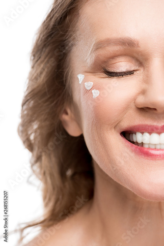 smiling mature woman with cosmetic cream on face Isolated On White