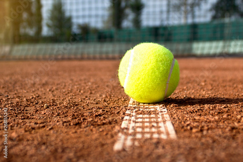 Tennis ball on the clay tennis court. Close up.
