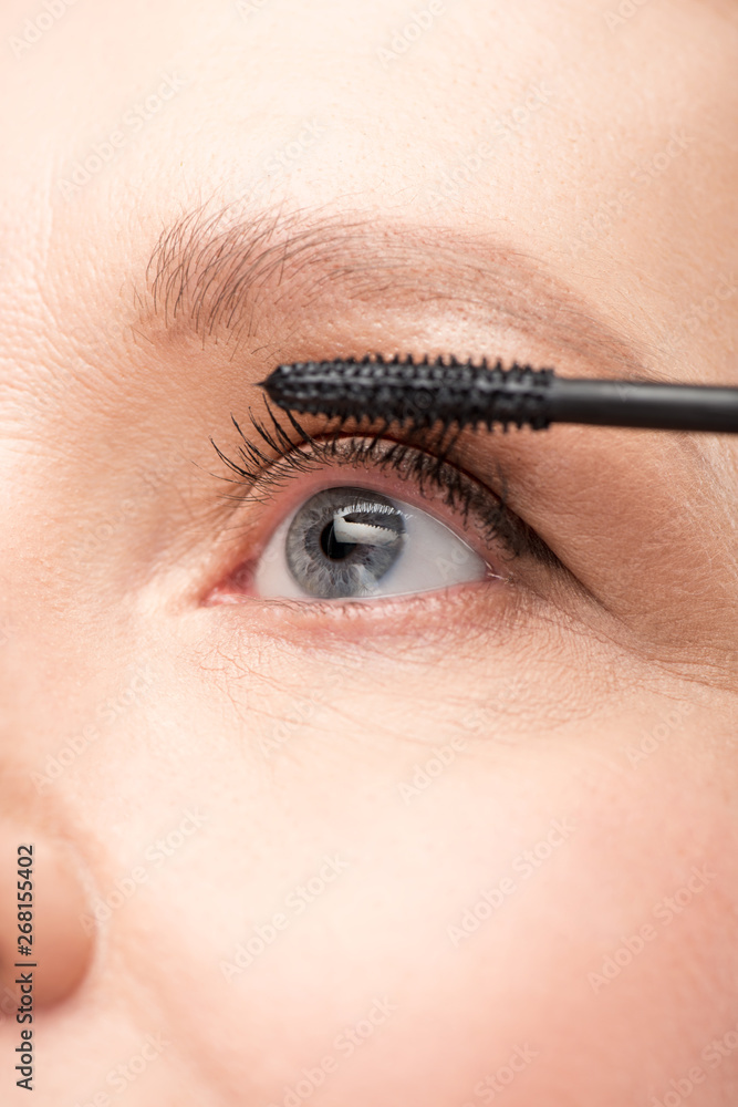 close up of mature woman applying mascara Isolated On White