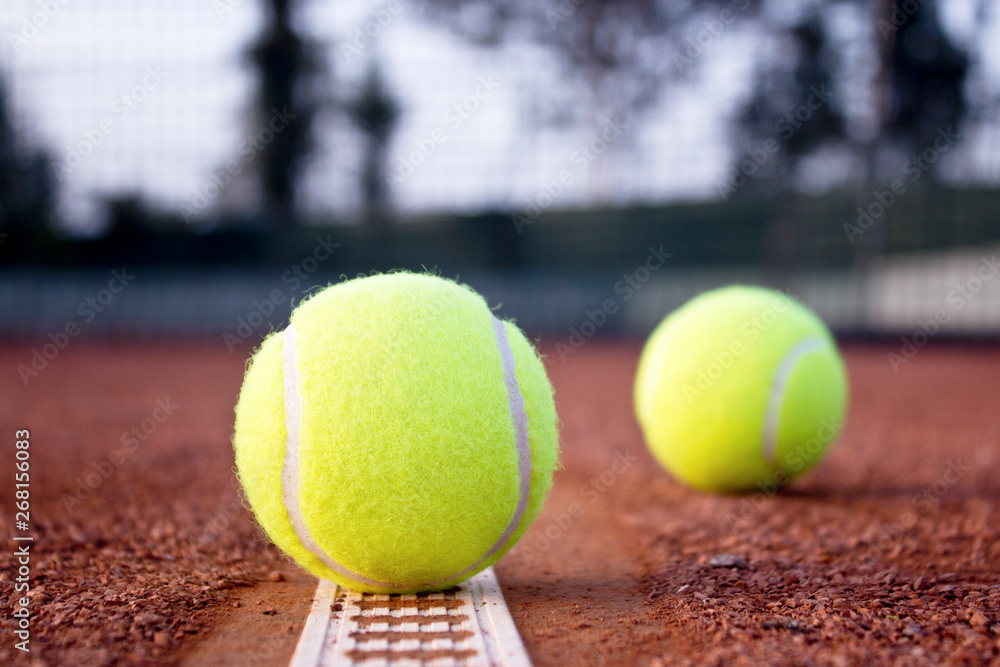 Tennis balls on the clay tennis court. Close up.