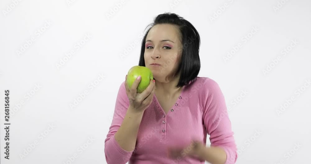 Young beautiful woman eating big, and juicy green apple on white background Young beautiful woman eating big, and juicy green apple on white background