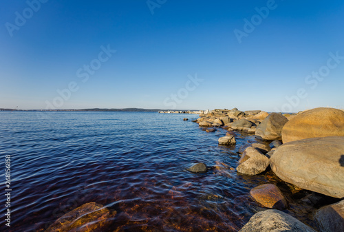 Beautiful shore of lake Onega. Petrozavodsk, Karelia. Water and stones on the shore of lake Onega.