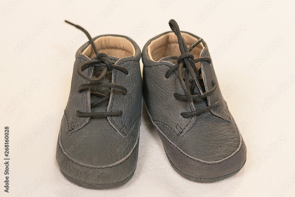 Isolated pair of grey leather baby boy shoes, cute children's lace-up soft sole footwear, toddler's fashionable clothing and accessories, shopping ideas for baby showers or as gift for the little ones